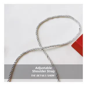 Detail view of the shiny silver metallic twisted rope adjustable strap on the bag