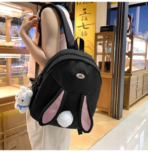 Detail of black rabbit backpack featuring plush 3D bunny ears and soft white pom-pom tail