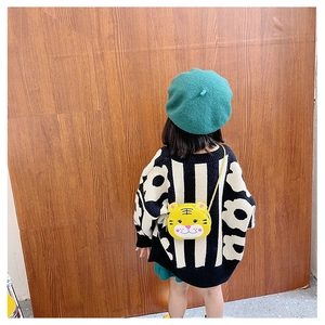 Detail of yellow tiger cartoon crossbody bag with golden chain on a child model