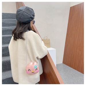 Detailed view of pink rabbit crossbody bag with blue flower on a child's shoulder