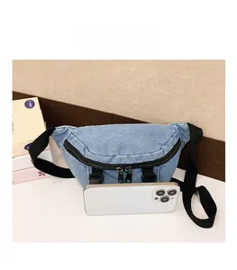 Confronto dimensioni del marsupio in denim azzurro accanto a uno smartphone