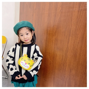 Detail of yellow tiger cross-body bag for kids with gold chain strap on a child model