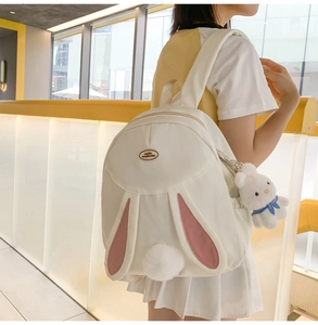Close-up of cute white rabbit backpack with plush ears and fuzzy bunny tail detail