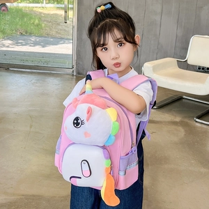 Zaino rosa per bambini con unicorno e peluche, indossato da un bambino in una stanza