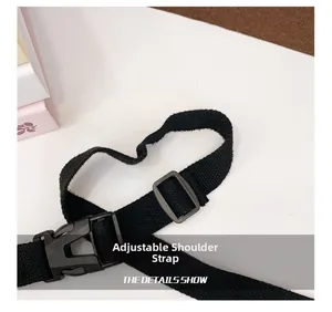 Dettaglio della tracolla regolabile in nylon nero con fibbia e cursore in plastica