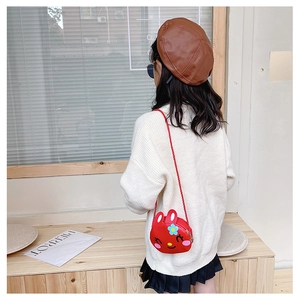 Detail of red cartoon rabbit shoulder bag featuring cute floral accents and strap