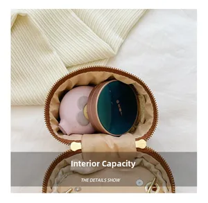 Macro view of the round crossbody bag interior showing storage space for makeup