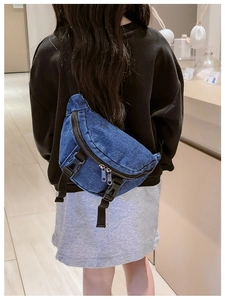 Dettaglio del marsupio in denim blu vintage con tracolla regolabile indossato a tracolla