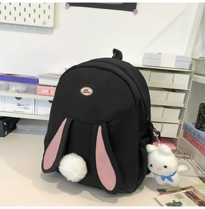 Close-up of a black backpack with cute pink bunny ears and a soft plush rabbit charm