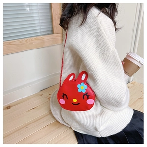 Close-up of a child wearing the red rabbit crossbody bag with cute floral detail