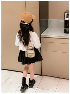 Toddler rainbow woven mini crossbody bag featuring a golden chain and brown leather strap