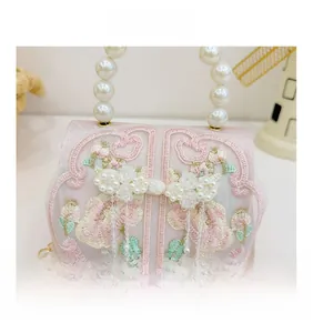 Detail of pink embroidered kids purse with pearl handle and Chinese style knot buckle