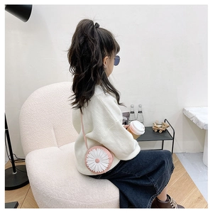 Pink daisy mini crossbody bag for kids shown being worn by a young girl in daily life