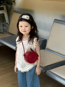 Detailed view of kids red round crossbody bag with metal chain and textured finish