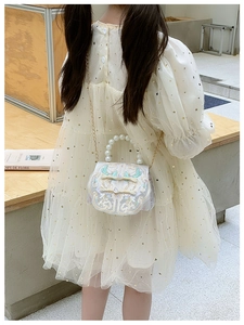 Detailed shot of kids vintage crossbody bag with pearl handle and classic embroidery