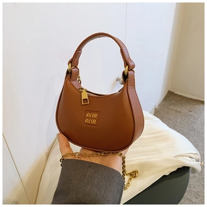 Close-up of brown crescent mini bag with lychee texture and gold chain strap detail
