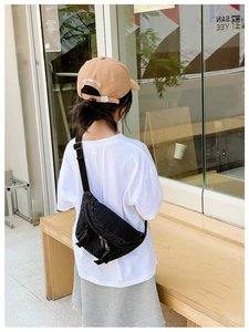 Dettaglio del marsupio in denim nero per bambini con doppie cerniere e fibbie regolabili