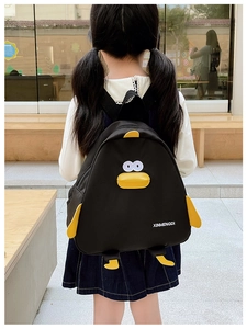 Détail d'un joli sac à dos pingouin porté par un enfant dans un cadre extérieur ensoleillé
