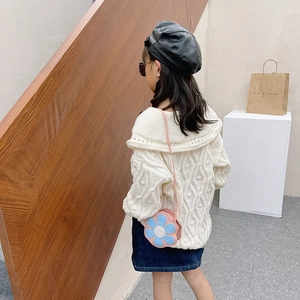 Kids colorful floral crossbody bag paired with a white cable knit sweater and denim skirt
