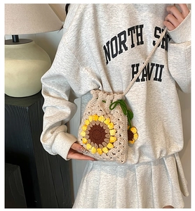 Close-up of handmade crochet sunflower bucket bag with drawstring and knit texture