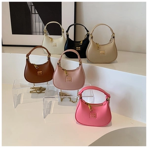 Detailed close-up of colorful mini half-moon leather bags with gold chain hardware