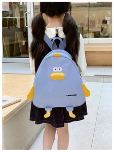 Enfant portant un sac à dos canard bleu clair avec bec jaune 3D en extérieur