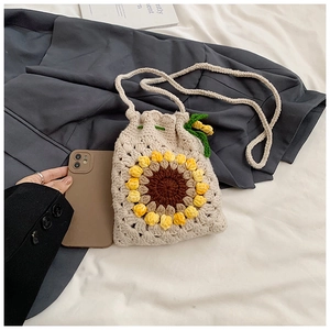 Detailed knit texture of handmade sunflower crochet crossbody bag with yellow petals