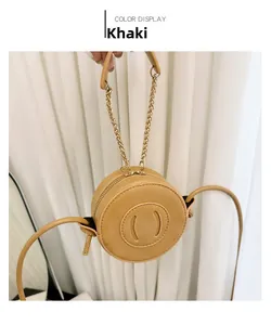 Detail of khaki round leather bag showing the smile-shaped stitching and gold chain handle
