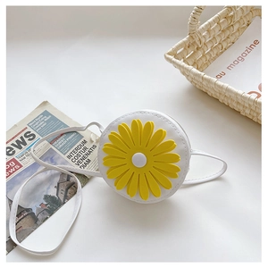 Detailed close-up of white round daisy crossbody bag with yellow flower on white background