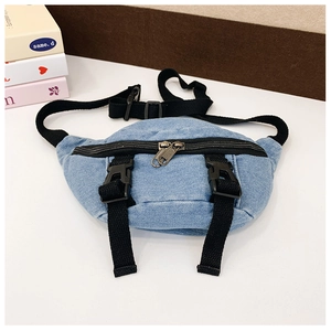 Dettaglio del borsello in denim azzurro con tracolla nera regolabile e cerniere in rame