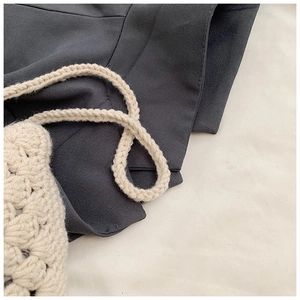 Detailed macro view of handmade cream crochet shoulder bag featuring intricate knit patterns