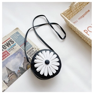Detail of cute black round crossbody bag with a large white daisy flower for kids