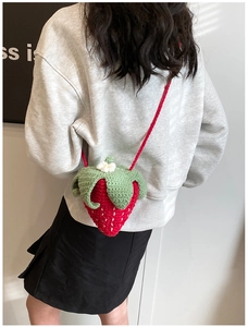 Détails de la sacoche fraise faite main au crochet avec feuilles vertes et texture rouge
