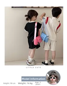 Vue de dos d'enfants portant des mini sacs à bandoulière roses et bleus en toile