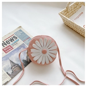 Close-up of pink round crossbody bag for kids featuring a large white daisy flower detail