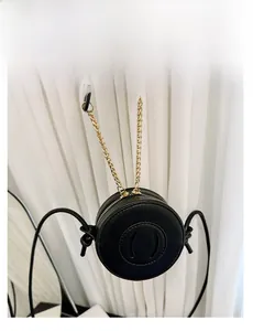 Detailed view of a black round mini PU leather crossbody bag with smiling face detail