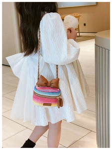 Detail of woven rainbow kids crossbody bag with leather bow and metal chain strap