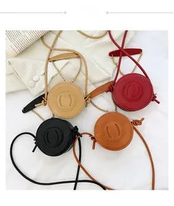 Mini round kids crossbody bags in beige, red, black, and brown with gold chain straps