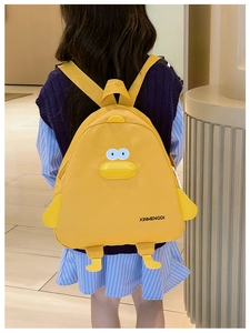 Détail du sac à dos canard jaune avec bec et ailes 3D porté par un enfant