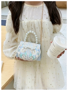 Detail of blue Chinese style kids bag with traditional embroidery and pearl handle