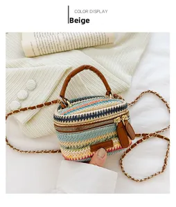 Detail of a striped woven mini bag with brown leather handles and a metal chain strap