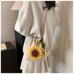 Detail of handmade crochet sunflower crossbody bag with woven texture and floral design