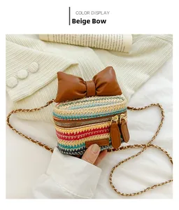 Detail of woven straw crossbody bag with brown PU leather bow and chain strap
