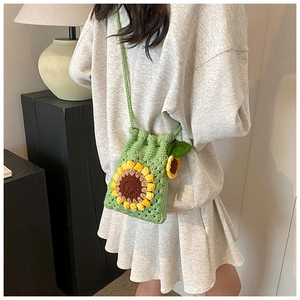 Close-up of handmade crochet sunflower crossbody bag with detailed green knit textures