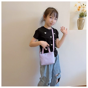 Asian girl wearing a lilac canvas crossbody bag for kids with adjustable shoulder strap