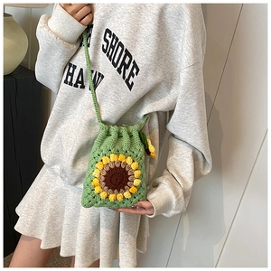 Detail showing hand-crocheted sunflower crossbody bag with drawstring closure and green texture