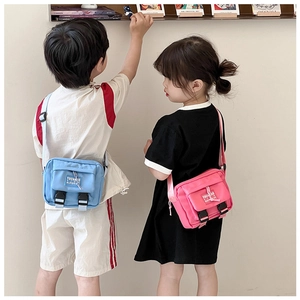 Deux enfants portant des sacs bandoulière en nylon bleu clair et rose avec sangle
