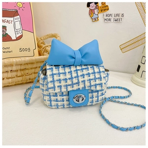 Detailed view of kids tweed plaid crossbody bag with a blue leather bow and metal twist lock