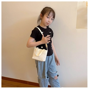 Minimalist white canvas kids crossbody bag styled with casual children's summer outfit