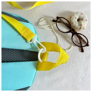Détail du sac à dos enfant bleu clair avec sangle jaune et dos en filet respirant